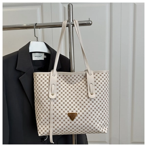 Détail du sac cabas rétro avec motifs circulaires géométriques et logo métallique