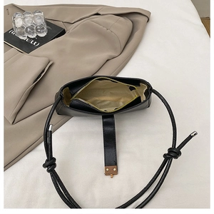 Detail showing internal lining and gold zipper of the black leather baguette bag