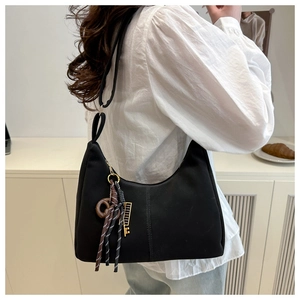 Black nylon shoulder bag featuring unique woven rope and golden key charm details