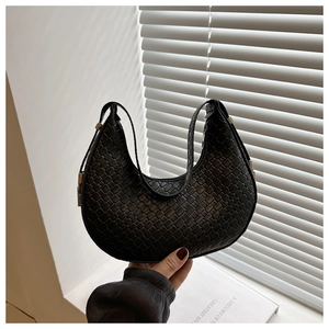 Detailed view of the black woven crescent hobo bag with a silver metal clasp