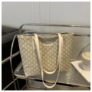 Detail of off-white monogram tote bag with M pattern on a stylish silver cart