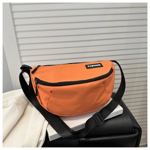 Detail of high-quality orange nylon bag with metal zippers and Fashion rubber label
