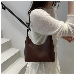 Chic dark coffee leather half-moon shoulder bag styled with a minimalist outfit