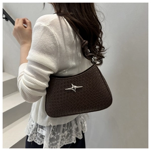 Detailed close-up of dark brown crocodile pattern handbag with star logo and braided strap