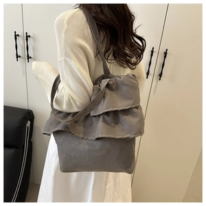 Detailed view of dark gray canvas tote bag with triple ruffle design and long shoulder straps