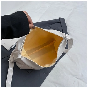 Detail of the white PU leather bag showing yellow fabric lining and interior space