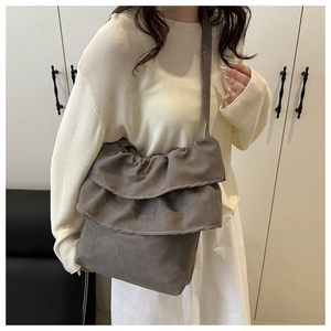 Close-up of ruffled canvas tote bag featuring multi-layer grey fabric pleated details