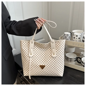 Détail du sac cabas à carreaux crème avec logo triangulaire doré et bandoulière