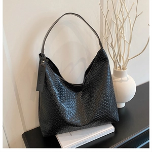 Detail of black woven texture tote bag with Fashion tag in a stylish setting
