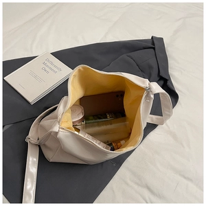 Detail of cream tote bag with yellow lining showing spacious capacity for phone and makeup