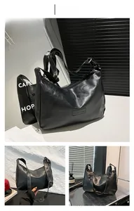 Detail of black PU leather shoulder bag featuring embossed FASHION logo and adjustable strap
