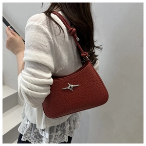 Detail of red woven shoulder bag with silver star ornament and knotted strap detail