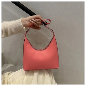 Detail of coral peach hobo bag featuring smooth leather finish and silver metal buckle