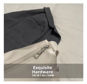 Close-up of polished silver zipper and fine leather texture on cream crossbody bag