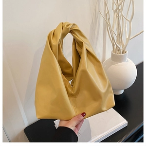 Detailansicht einer ingwergelben Falten-Eimertasche aus weichem PU-Leder-Material