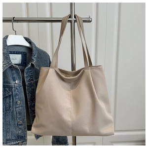 Close-up of beige nylon tote bag with decorative stitching on a hanger