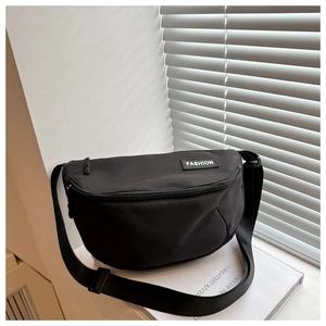 Detailed view of black nylon dumpling crossbody bag with adjustable wide shoulder strap