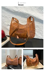 Detail of vintage brown PU leather bag featuring fashion embossed tag and wide strap