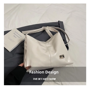 Detail showing high-gloss cream PU leather texture and golden metal plaque on tote bag