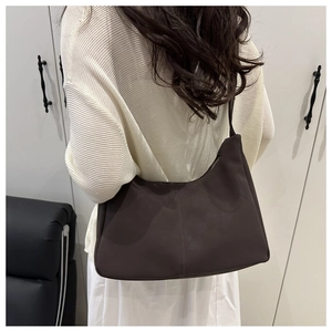 Detail view of deep brown hobo bag with matte leather texture and slim shoulder strap