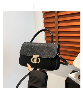 Detail of black PU leather bag with silver glitter flap and gold hardware lock