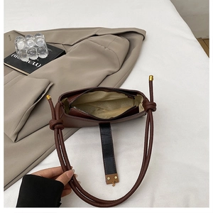 Internal view of brown shoulder bag showing light lining and zippered inner pocket