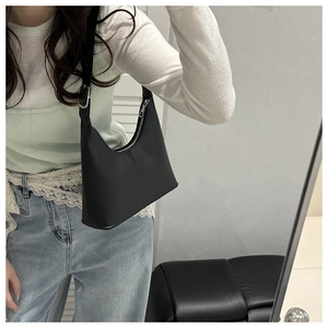 Detail view of the sleek black crescent hobo bag with adjustable silver buckle shoulder strap