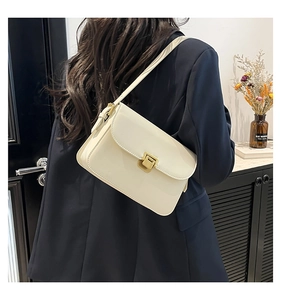 Détail d'un sac à bandoulière minimaliste en cuir blanc cassé avec un fermoir doré