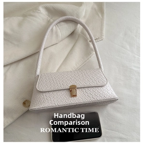 Detail of cream woven shoulder bag with gold clasp shown next to a smartphone for scale