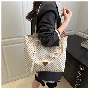 Détail d'un grand sac cabas blanc à motifs géométriques et plaque logo triangulaire