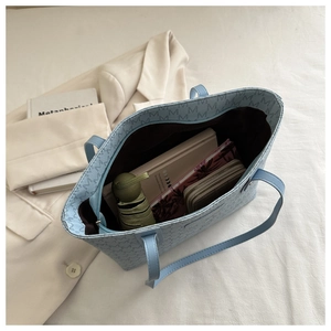 Interior view of light blue tote bag showing large capacity for umbrella and notebook