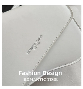 Detail of white leather saddle bag with Fashion Trend Est 1996 embossed on the flap