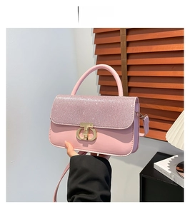 Detailed view of pink shoulder bag featuring sparkling rhinestones and a gold metal lock