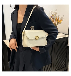 Détail d'un sac à bandoulière en cuir blanc crème avec boucle en métal doré élégante