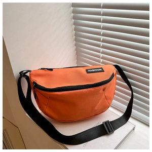 Close-up of vibrant orange crossbody bag with black zipper and adjustable nylon strap