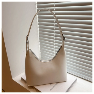 Macro detail of creamy white shoulder bag with smooth matte finish and metal zipper