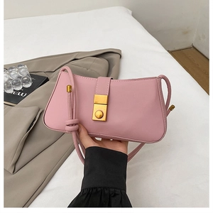 Detail of pink faux leather underarm bag with elegant gold metal lock and knotted strap