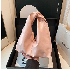 Detail der weichen rosa Faltenhandtasche mit einzigartigem Knotengriff und glattem PU-Leder