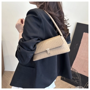 Détail du motif crocodile kaki sur le sac bandoulière avec boucle en métal doré