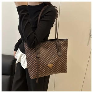 Sac cabas marron à motif géométrique porté sous le bras pour montrer sa taille réelle