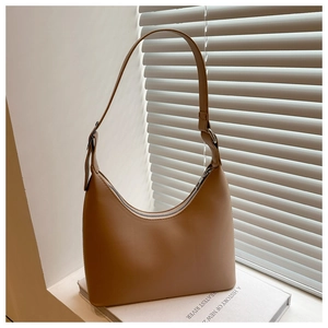 Close-up of tan crescent underarm bag showing matte PU leather and silver metal zipper detail