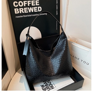 Close-up of woven texture on a large black hobo shoulder bag with a fashion tag