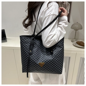 Détail d'un grand sac cabas avec motif à cercles gris et logo triangulaire doré chic