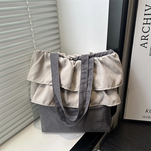 Two-tone ruffle tote bag in grey canvas with elegant pleated edges and soft texture