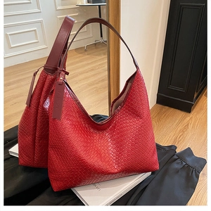 Macro detail of red woven faux leather tote with fashion label and wide shoulder strap