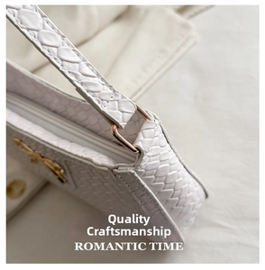 Detailed macro view of white faux leather snake skin texture and metal D-ring hardware