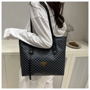 Détail du sac cabas imprimé avec plaque en métal et bretelles en cuir noir