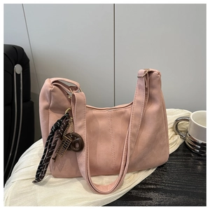 Detail of pink suede hobo bag featuring a unique abacus and woven cord decorative charm
