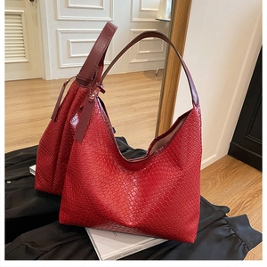 Detail of red woven hobo bag showing intricate leather texture and wide shoulder strap