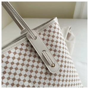Détail de la texture cuir grainé, imprimé floral et garnitures dorées sur le cabas